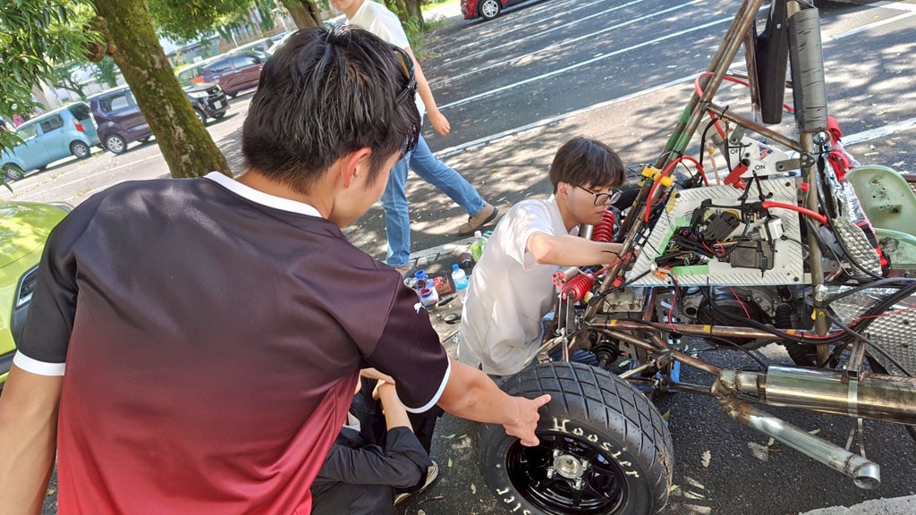 これは群馬大学学生フォーミュラチーム (GUFT) が大会に向けて取り組んでいる写真です。 ​
